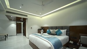 Una habitación de hotel moderna con una cama grande, mesitas de noche, un escritorio y un ventilador de techo.