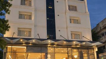 Un edificio de hotel con un cartel llamativo que dice 'Vajram Kyiad' y un logotipo sobre la entrada.