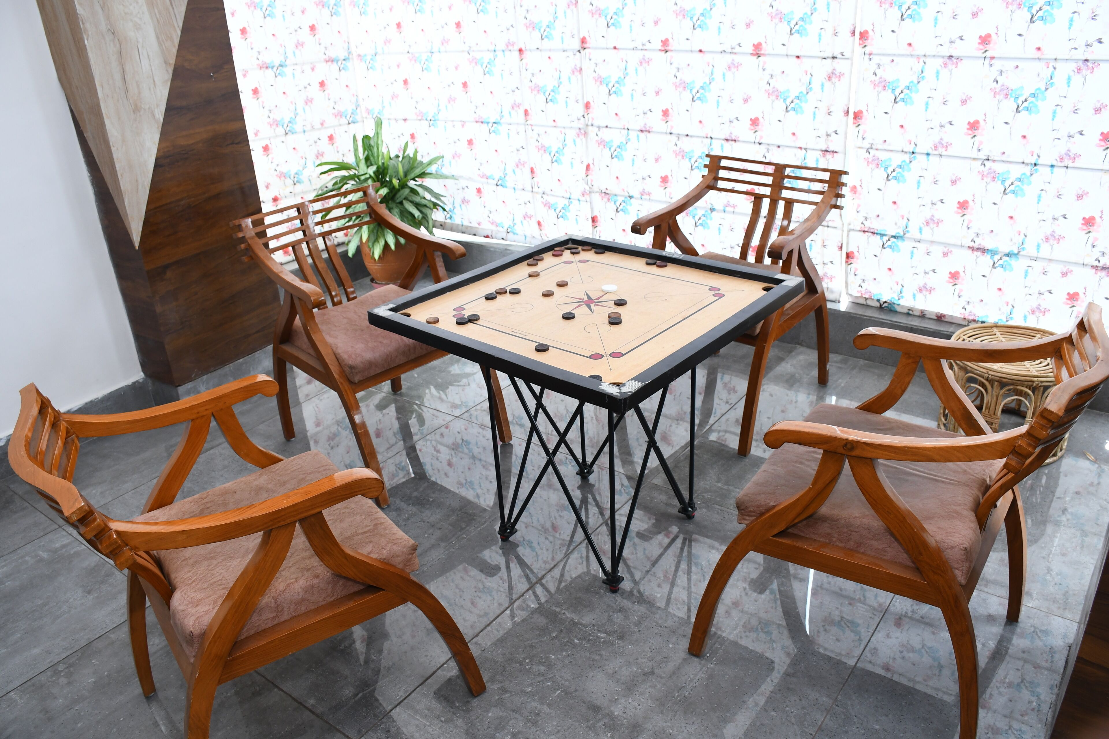 Een kamer met een tafelvoetbaltafel, omringd door houten stoelen.