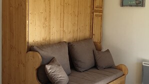 Eine Holzbank mit Kissen, eine Holzvertäfelung an der Wand und ein Schild mit der Aufschrift "Home sweet home".
