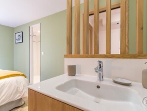 A bathroom with a white sink, a mirror, and a wooden door.