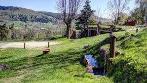 A rural landscape with a stone bridge, a small stream, and a wooden fence. - Spacious lodge with fireplace and forest terrace, pets allowed (La Versanne)