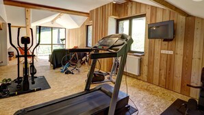 A gym with exercise equipment, a treadmill, and a large window. - Spacious lodge with fireplace and forest terrace, pets allowed (La Versanne)