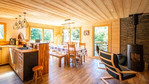 A spacious kitchen with wooden cabinets, a dining area with a table and chairs, and a cozy seating area with a fireplace. - Luxury Chalet with Spa, Near Ski Resorts, Sleeps 8 (Ban-sur-Meurthe-Clefcy)