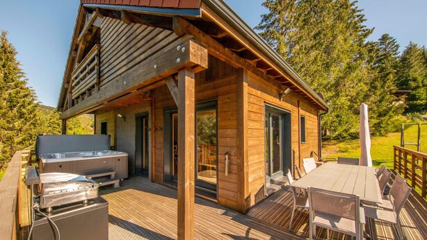 A wooden cabin with a hot tub, outdoor seating, and a deck. - Luxury Chalet with Spa, Near Ski Resorts, Sleeps 8 (Ban-sur-Meurthe-Clefcy)