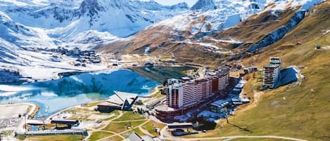 A mountainous landscape with a large body of water, a ski resort, and several buildings including a hotel.