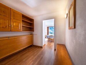A hallway with wooden cabinets, a bench, and a view of a dining area with a table and chairs. - Spacious apartment in Tignes, 9 guests, pets allowed, ski-in/out (Tignes)
