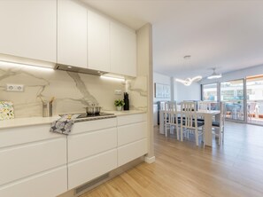 Enjoy meals in this kitchen with stove, dining area, and large window offering a view.