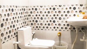 A bathroom with a toilet, a bidet, and a sink. - Roomshala 021 Hotel Joyous Inn (Ghaziabad)