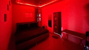 A room with a bed, a small table, and a mirror. - Roomshala 021 Hotel Joyous Inn (Ghaziabad)