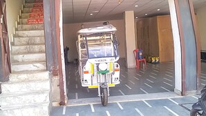 A building with a sign reading "JOYOUS INN" and a parked three-wheeled vehicle in front. - Roomshala 021 Hotel Joyous Inn (Ghaziabad)