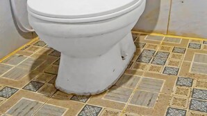 A white toilet with a tank, a white pipe, and a tiled floor with a pattern. - Hotel O Abadi Hotel (Medan)