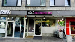 Fachada moderna del Hotel Düsseldorfer Hof, con una amplia entrada de vidrio y el letrero de la dirección a la vista.