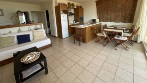 A compact living space with a kitchenette, a dining area, and a sofa. - Apartment in Aiguablava with Pools and Wifi (Begur)