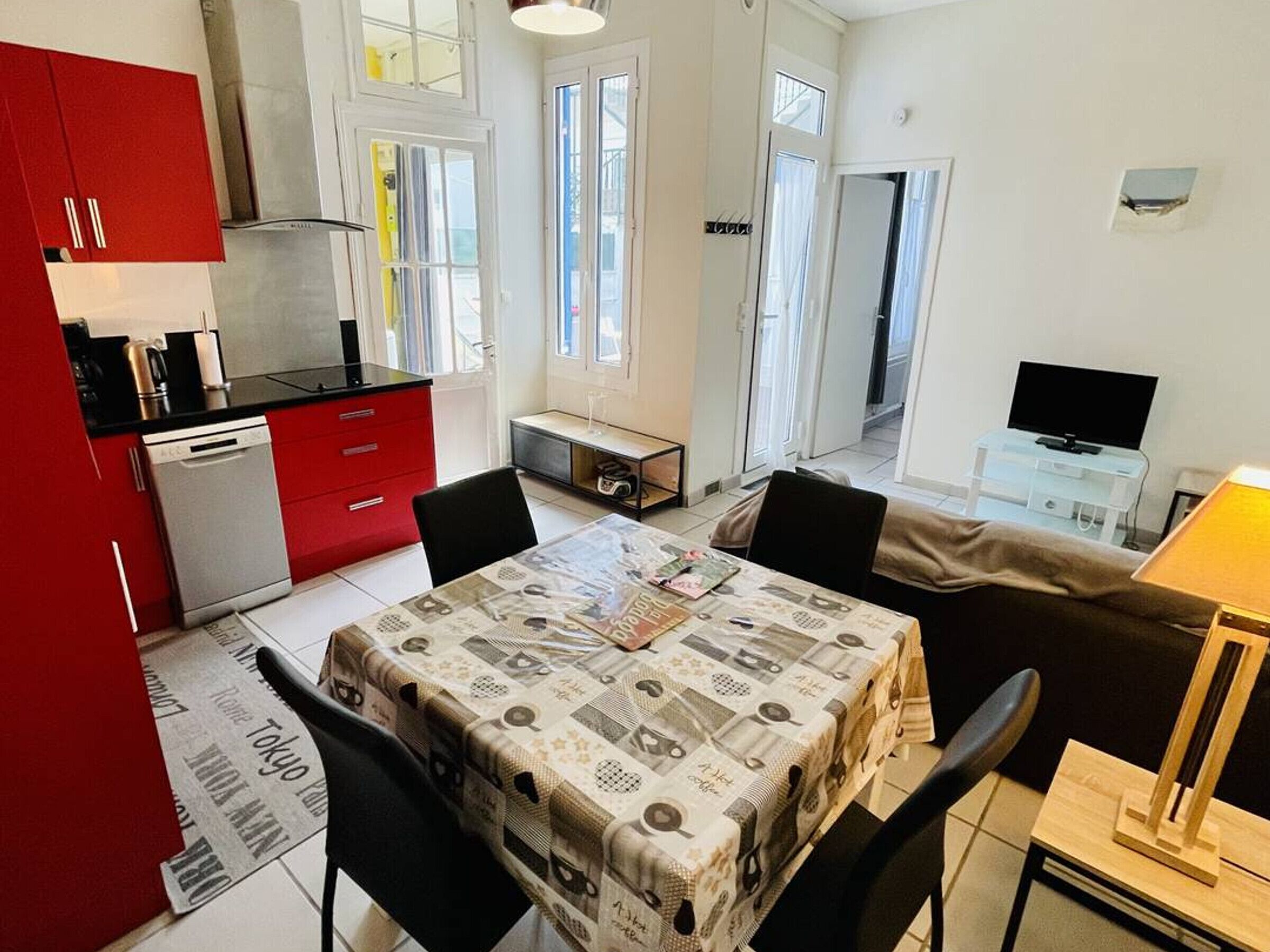 A compact living space with a kitchenette, dining area, and a TV.