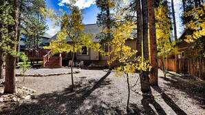 A residential area with a wooden deck, a stone pathway, and a house with a covered porch.