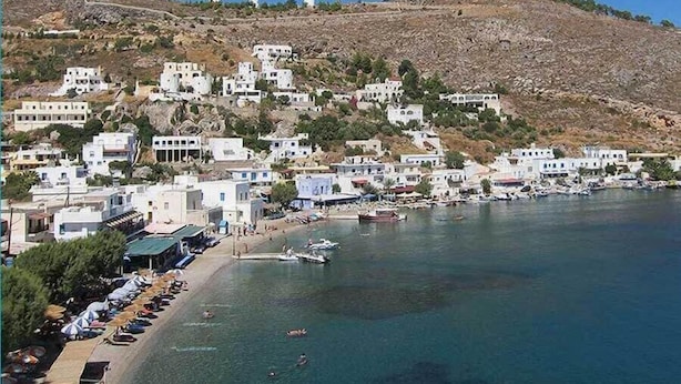 A coastal town with white buildings, a beach, and boats.