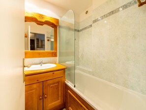 A bathroom with a wooden vanity, a white sink, a glass shower enclosure, and a bathtub. - Spacious ski-in/ski-out apartment for 10 with balcony, pets allowed (Tignes)