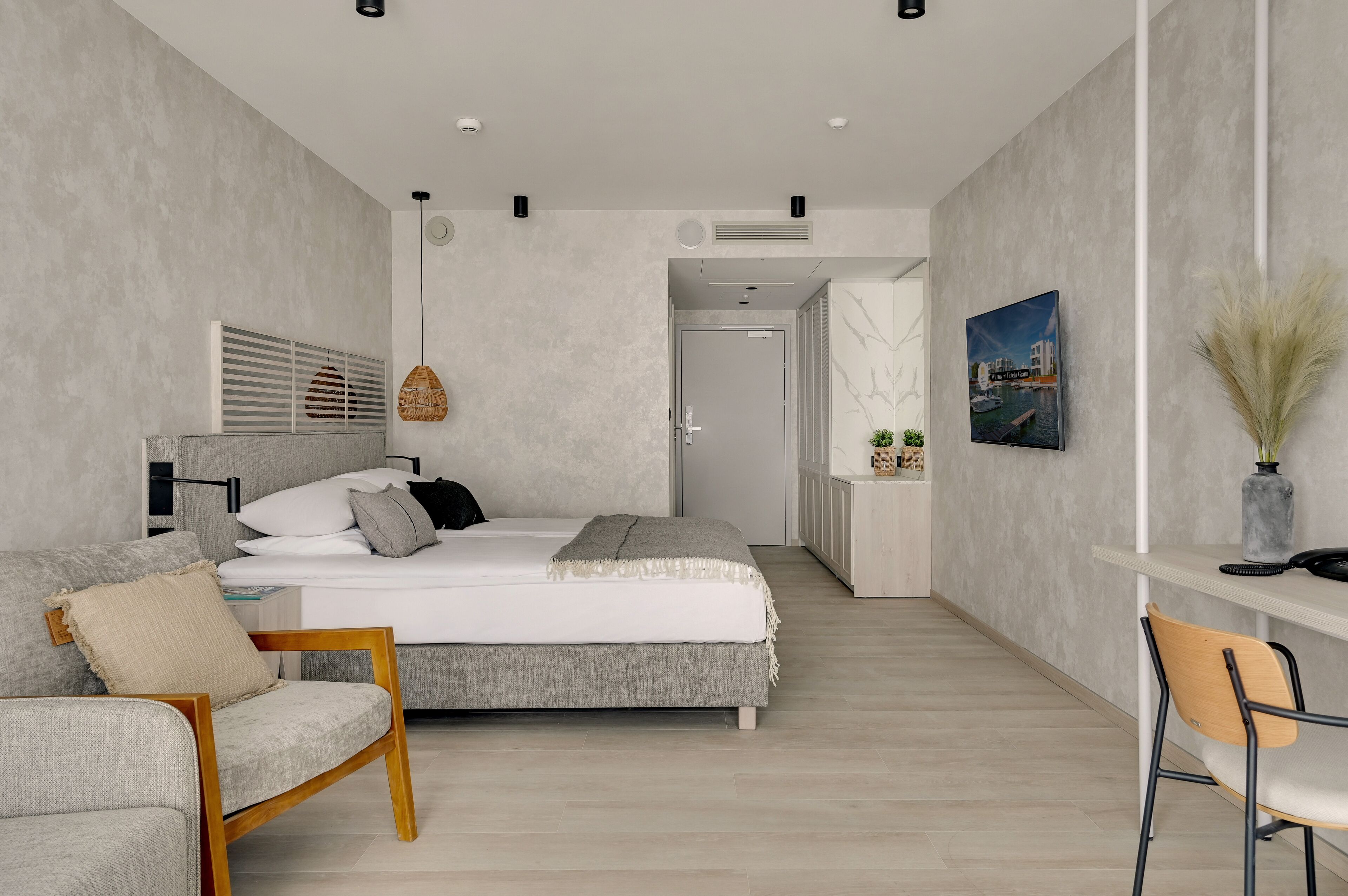 Un dormitorio moderno con una cama, un escritorio y una silla.