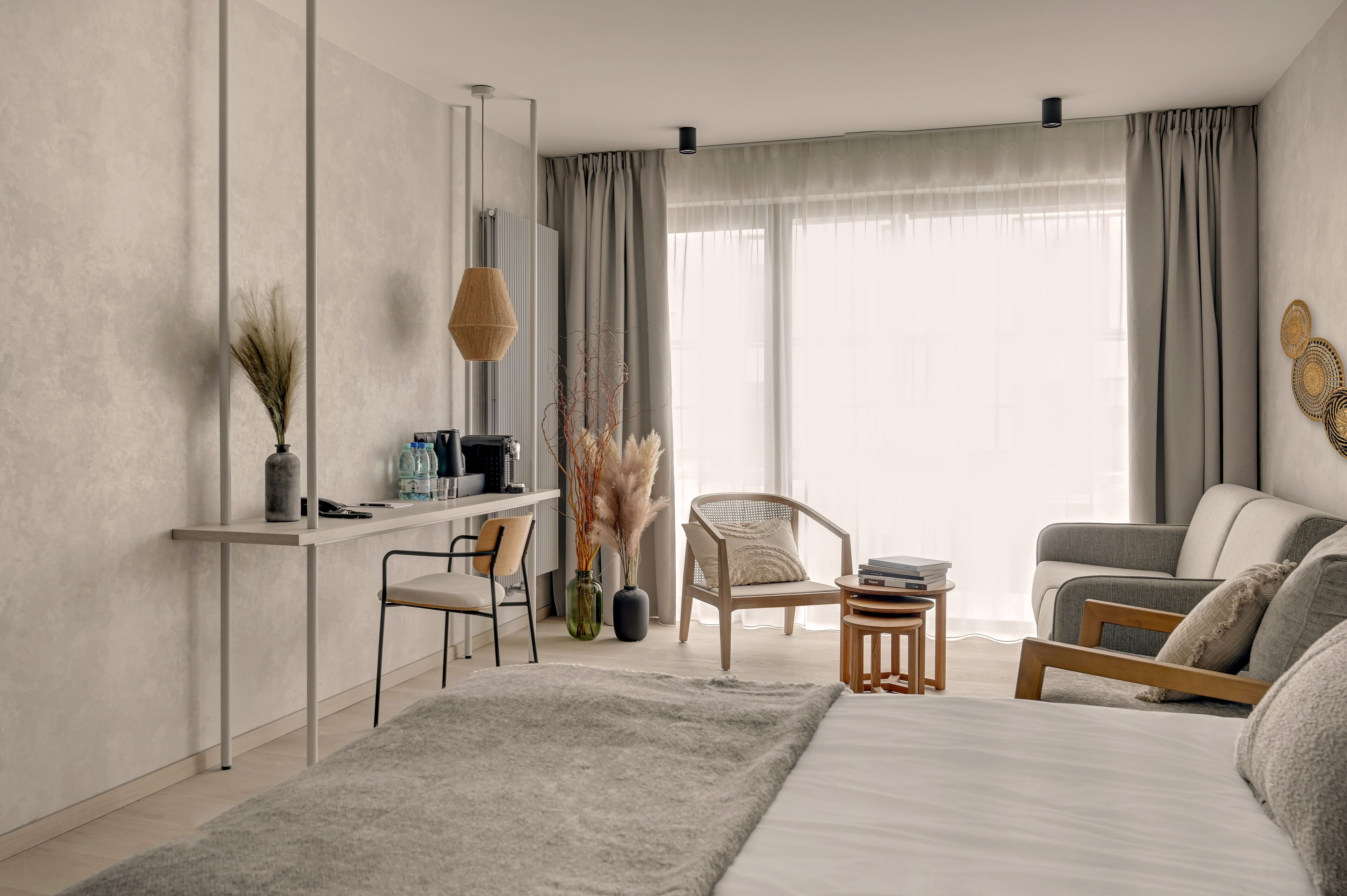 Una camera da letto moderna con un letto, una scrivania, una sedia e un divano.