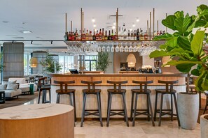 Eine Bar mit Hockern, einer Theke und einer Auswahl an Flaschen und Gläsern.