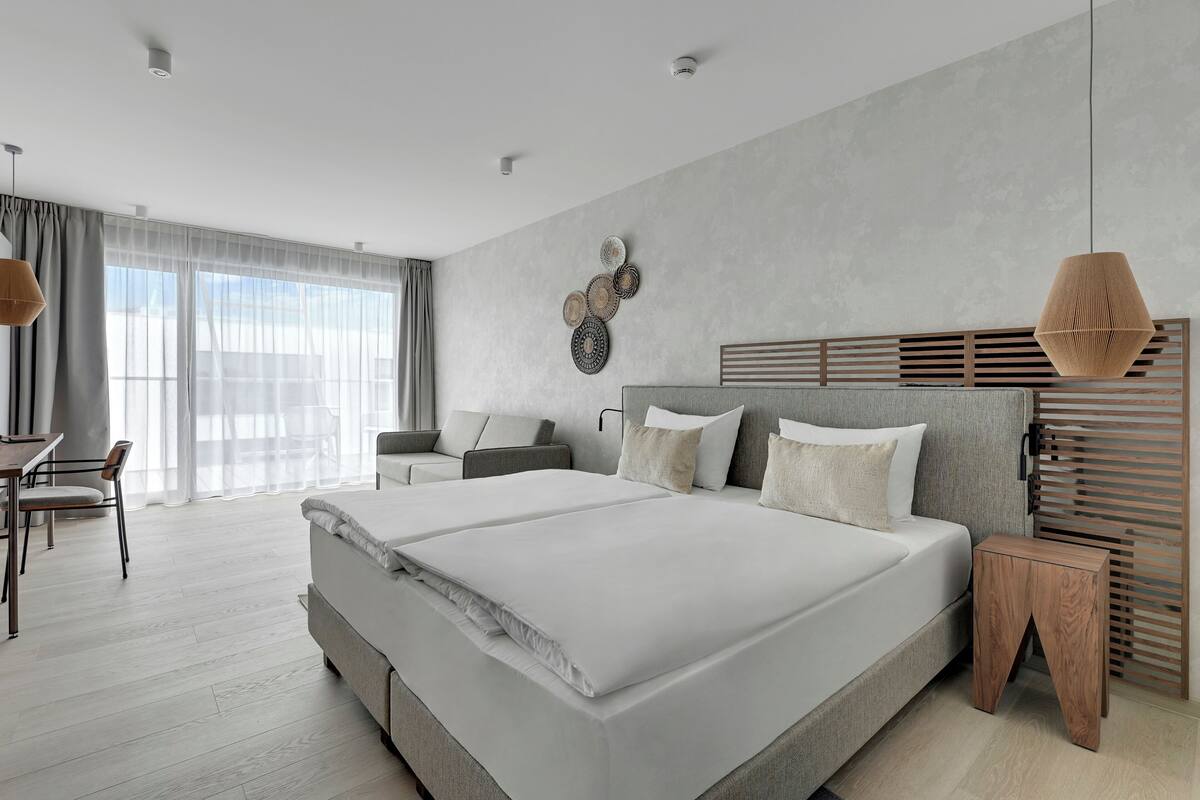 Un dormitorio moderno con una cama grande, un escritorio y una silla.