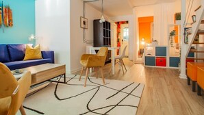 A modern living room with a blue sofa, yellow cushions, a wooden coffee table, and a patterned rug.