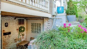 A rustic building with a brick facade, a wooden bench, and a potted plant.