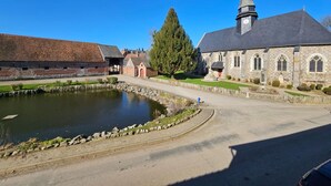 Ein historisches Gebäude mit Kirche, Teich und Steinmauer.