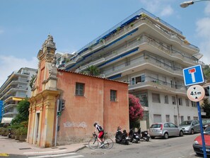 A street scene with a cyclist, parked scooters, and cars. - Stunning 2BR Top-Floor Apt with A/C, Sea View Terrace, Near Beach & Center (Menton)