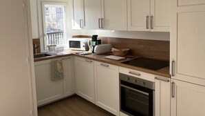 Una cocina con armarios blancos, microondas, tostadora y horno.