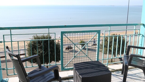 A balcony with a view of the sea, a metal gate, and two chairs. - 4-person apartment with sea view, beachfront (Fouras)