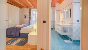 A bedroom with a bed, bedside table, and a window with curtains. - Concordia Apartment Laveno (Laveno Mombello)