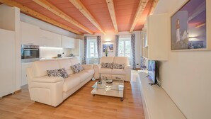A modern living room with a sofa, a coffee table, and a television. - Concordia Apartment Laveno (Laveno Mombello)
