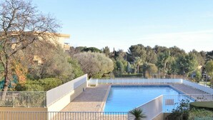 A rooftop pool with a view of surrounding trees and buildings.