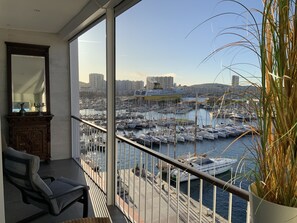 A balcony with a view of a marina, a chair, a potted plant, and a mirror. - Beautiful! Toulon, with a view of the harbor and the sea (Toulon)