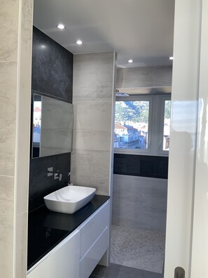 Regadera, secadora de cabello, toallas, papel de baño 