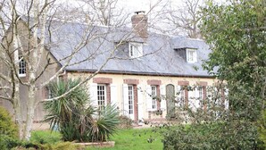 A traditional house with a brick facade, white shutters, and a grey roof. - Charming house with enclosed garden in Saint-Pierre-des-Loges (Saint-Pierre-des-Loges)