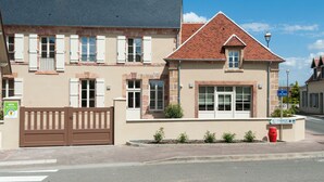 A two-story building with a beige facade, a red-tiled roof, and a gated entrance. - Spacious Countryside Retreat with Game Room and Accessible Facilities (Loye-sur-Arnon)