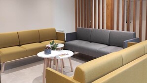 A modern living room with a yellow sofa, a grey sofa, and two small white tables with decorative items. - Spacious Countryside Retreat with Game Room and Accessible Facilities (Loye-sur-Arnon)