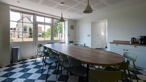 A modern kitchen with a large wooden table, several chairs, and a coffee machine. - Spacious Countryside Retreat with Game Room and Accessible Facilities (Loye-sur-Arnon)