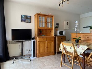 Cozy living space with a kitchenette, flat-screen TV, and dining area.