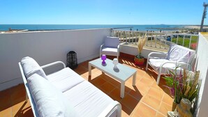A terrace with white furniture, a small table, and a view of the sea. - Stunning T3 with sea view terrace, parking (Sète)