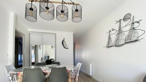 A dining area with a table, chairs, and a ceiling light fixture.
