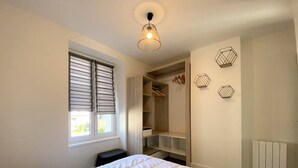 A bedroom with a bed, a closet, and a window with blinds.
