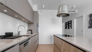 A modern kitchen with stainless steel appliances, a wooden countertop, and a pendant light. - Spacious 3BR apartment with 2 bathrooms (Reykjavík)