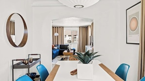 Un comedor moderno con una mesa larga, sillas azules y una planta en el centro.