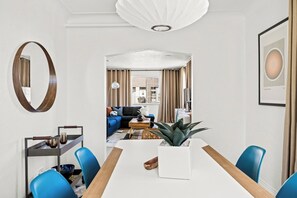 Une chambre d’hôtel moderne dotée d’un coin repas, d’un salon et offrant une vue sur l’extérieur.