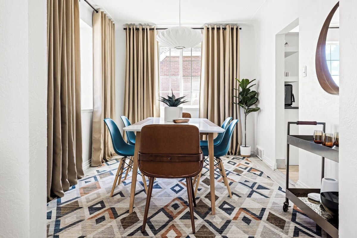 A dining area with a table, chairs, and a patterned floor.
