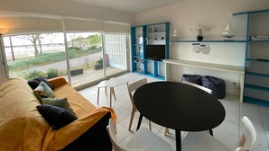 A modern living room with a sofa, a dining table, and a TV. - Ground floor apartment, 4 people, pool, beach 200 m, wifi (Fouras)